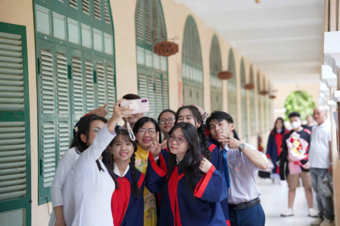 Hữu Thiện (áo trắng, đứng ngoài cùng bên phải) chụp hình cùng các bạn trong ngày tốt nghiệp
