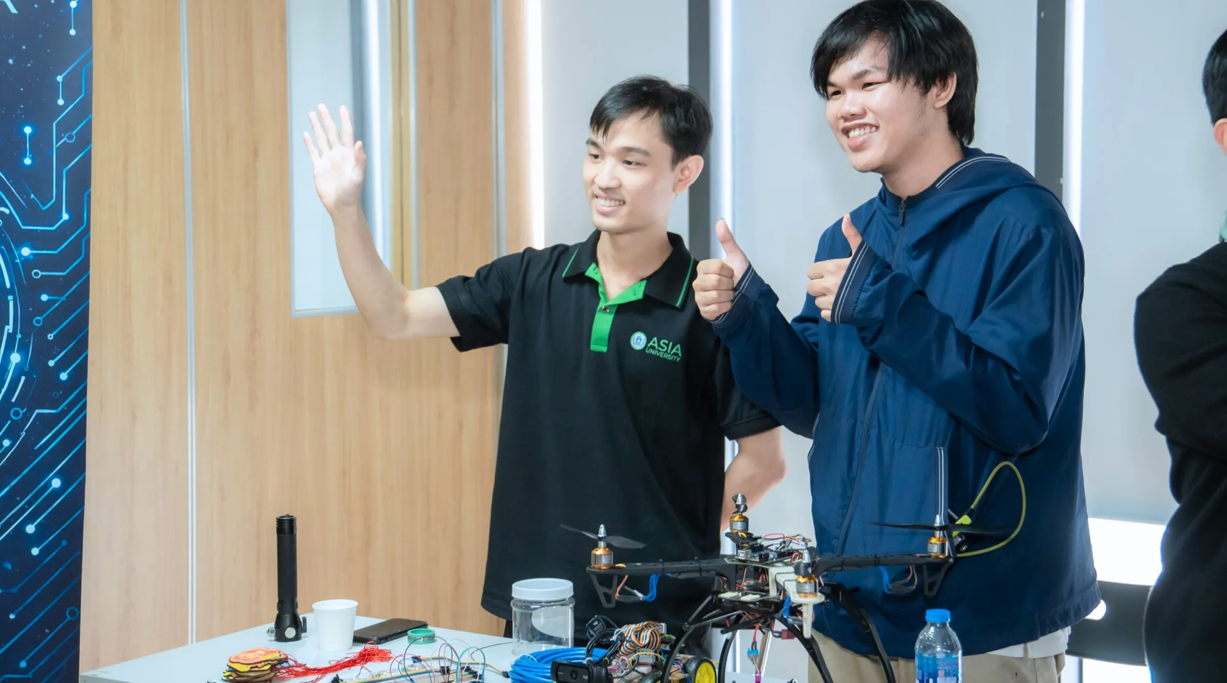 Trần Quốc Vân Long (bên trái) cùng thành viên trong câu lạc bộ giới thiệu và hướng dẫn học sinh, phụ huynh trải nghiệm các sản phẩm công nghệ